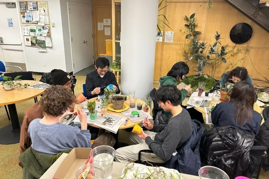 Undergrad students painting planters